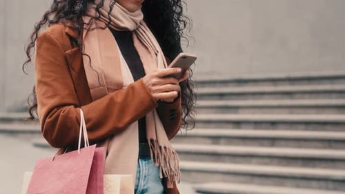 Femme méconnaissable, cliente inconnue, vêtue d'un manteau tendance, écharpe élégante et tendance, debout en ville