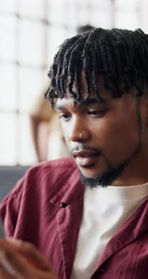 Young Man Uses Tablet Device While Another Stands Behind