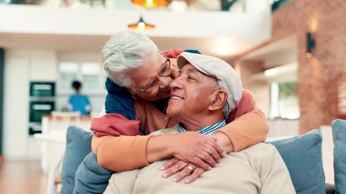 Affectionate Senior Couple Embracing at Home on Couch