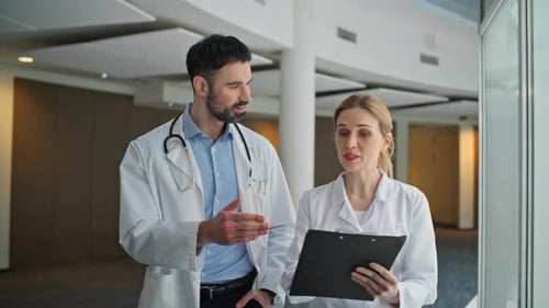 Doctors Discussing Medical Details in Hospital Hallway