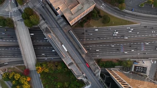 Top down aerial of highway traffic. Highrise skyscrapers along interstate freeway in USA.