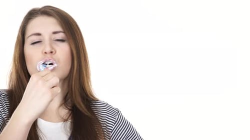 Woman Brushing Teeth Against White Background