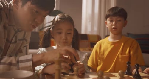 Family Plays Chess Together in the Living Room