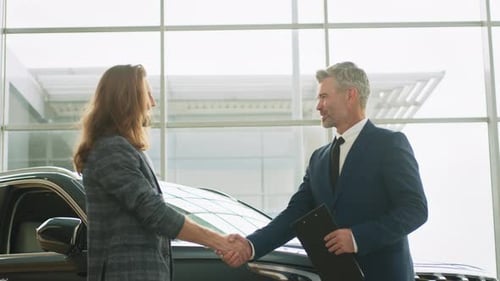 Buyer of Car Shaking Hands with Seller in Auto Dealership Closeup of Handshake