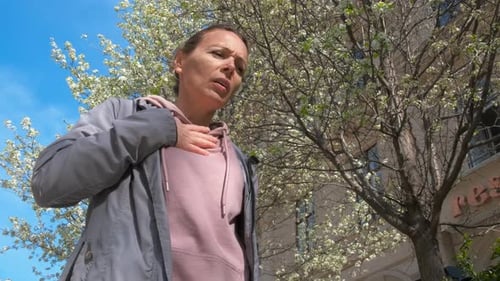 Femme qui éternue et souffre près de l'arbre