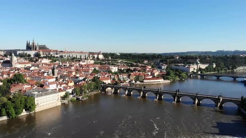 Aerial flyover over Vltava river in Praha, Czech Republic with a view of the Charles Bridge and the