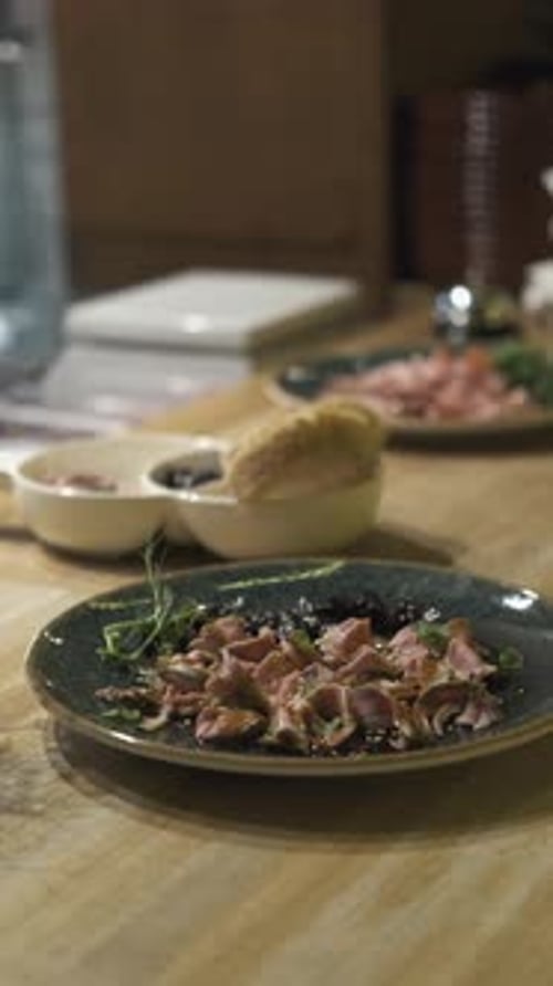 plates with meat salad on the restaurant serving table, vertical video