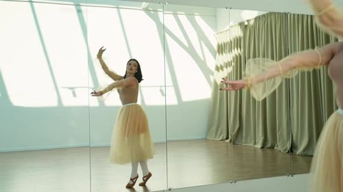 Graceful Ballerina Practicing Dance Moves in a Sunlit Studio