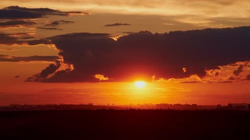 As the sun sets, dark storm clouds gather in the sky, bringing rain and unsettled weather, timelapse