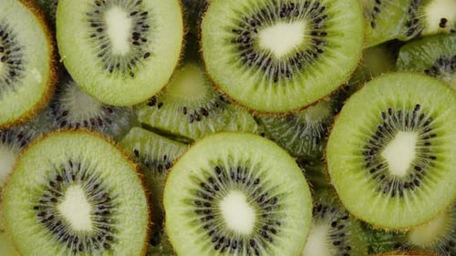 Close Up of Kiwi Fruit Slices Rotating on White Background