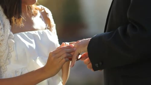 Bride Places Ring on Groom's Finger During Wedding
