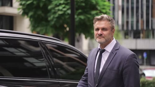 Business Man Takes Off Sunglasses in Urban Setting