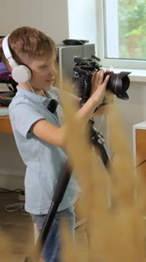 Vertical A Young Boy Learns Videography and Photography Using a Camera