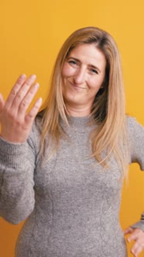 Mujer juguetona haciendo señas y gesticulando para que venga aquí en posición vertical