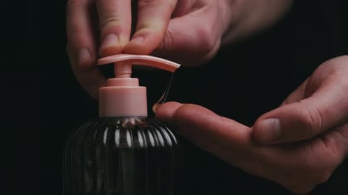 Nahaufnahme der Hände beim Drücken der Seifenpumpe mit Schaumbildung auf den Handflächen für Hygiene und Keimschutz