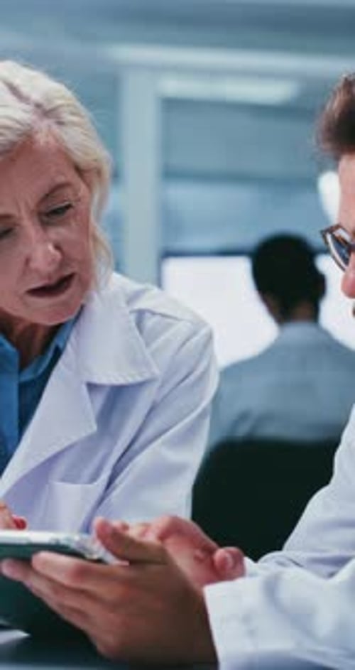 Doctors Reviewing Medical Data on a Tablet in Lab