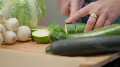 Slicing Fresh Green Zucchini on Board