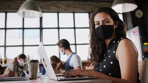 Jeunes gens d'affaires avec des masques faciaux travaillant à l'intérieur du bureau, concept de coronavirus
