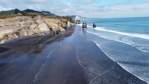 A scenic view of a The Three Sisters and the Elephant Rock beach on a hot summer day in New Zealand