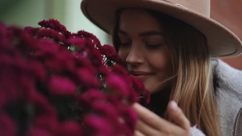 Woman Smelling Pink Flowers in the City