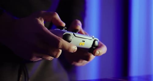 Close Up Hands Holding Game Controller in Blue Ambient Light, Gaming at Night