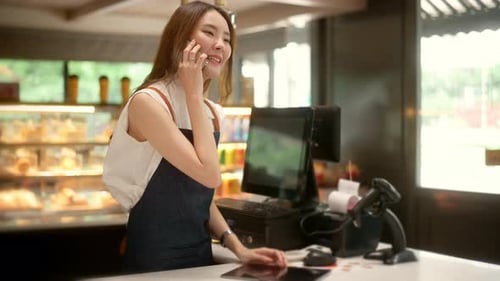 An Asian young Cashier woman working in supermarket