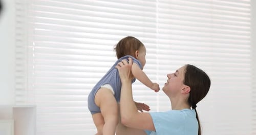 Glückliche Mutter und ihre süße kleine Tochter verbringen Zeit miteinander zu Hause
