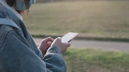Close up of woman hands outdoors using her phone to check social media apps and stay connected with