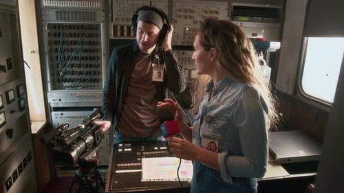 Reporter and Operator Checking Microphone Sound before Recording News Piece