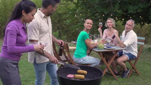 Friends Enjoying Barbecue and Summer Gathering Outdoors
