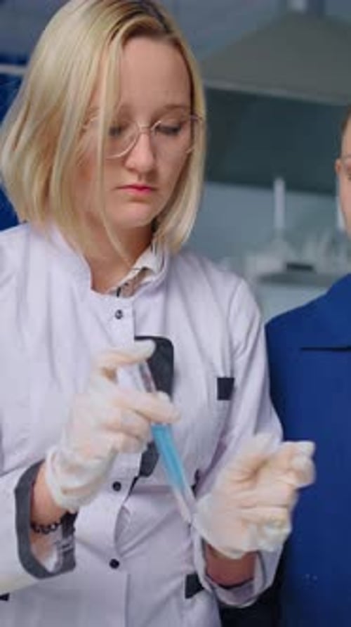 Young Woman Scientist Working with Syringe in Laboratory