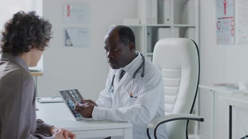 Doctor Explains Medical Scan to Patient in Office