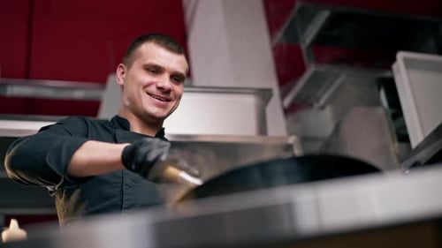 Chef cooking in frying pan in a restaurant