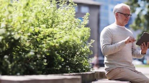 Senior man using tablet in city park setting
