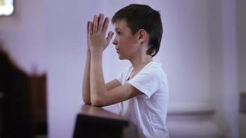 Sacred Reflections Young Boy Engaged in Prayerful Moments Within a Church