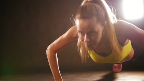 Attractive Sportive Woman in the Fitness Studio Doing Pushups Exercises
