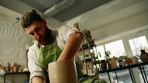 Ein Mann stellt einen Tontopf auf einer Keramikscheibe her Keramik Nahaufnahme Ein Töpfer macht Töpferhandwerk
