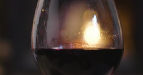 In winter, before the fireplace, is poured, tasted red wine in a glass. Concept of: relax, restaur