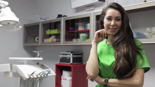 A Smiling Female Dentist Working in a Modern Clinic Environment with Advanced Equipment
