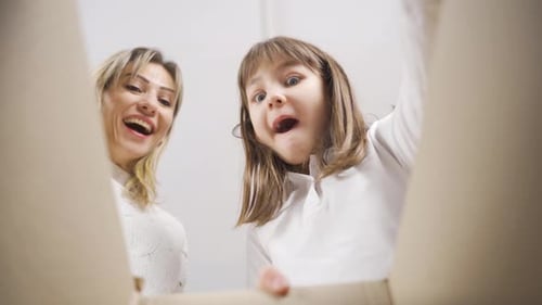 Excited Mother and Child Opening Birthday Box