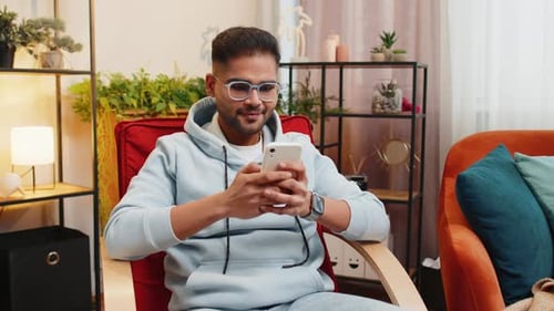Man Using Smartphone While Sitting in Armchair