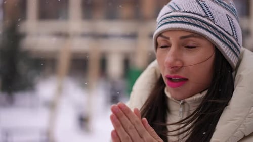 Woman Warming Hands Outside on Cold Winter Day