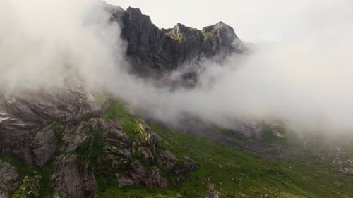 Soaring Through the Clouds Drone Ascending to Sunny Mountain Peak
