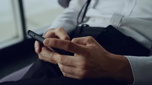 Nahaufnahme der Hände eines jungen Mannes, der den Bildschirm auf dem Handy berührt