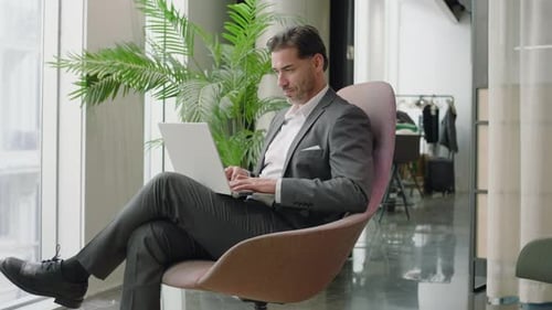 A Focused Businessman Diligently Works in a Modern Sleek Office Promoting Productivity