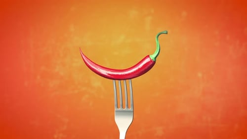 Piment rouge piquant coincé sur la fourchette autour de différentes fourchettes