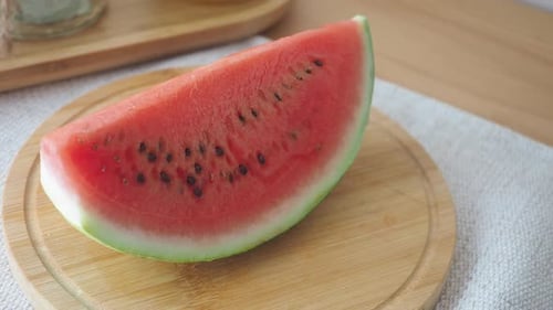 Enjoying Fresh Watermelon on a Wooden Cutting Board