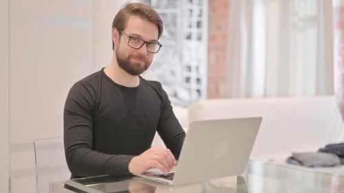 Man at Computer Gives Thumbs Up Gesture