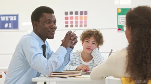 Teacher Working with Students at School Desk