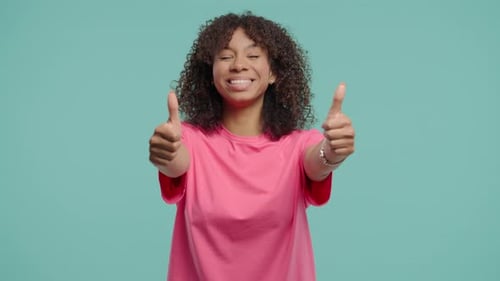 Smiling woman giving thumbs up on blue background